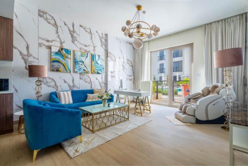 a living room with a blue couch and a table at GuestReady - Stylish blue elegance in La Cote in Dubai