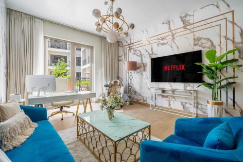 a living room with a blue couch and a tv at GuestReady - Stylish blue elegance in La Cote in Dubai