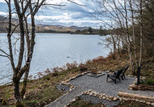 a bench and a table next to a lake at Alba Pod in Fort Augustus