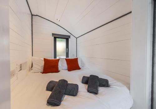 a bed in a white room with pillows on it at Alba Pod in Fort Augustus
