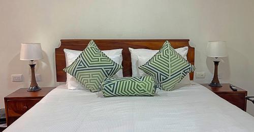 a bed with two pillows on it with two lamps at Casa Jungle Monteverde B&B in Monteverde Costa Rica