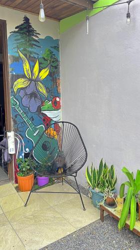 a bench sitting in front of a wall with a painting at Casa Jungle Monteverde B&B in Monteverde Costa Rica
