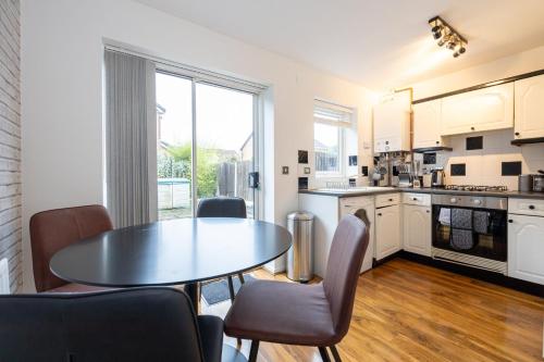 - une cuisine et une salle à manger avec une table et des chaises dans l'établissement GuestReady - Charming Retreat near Salford Quays, à Manchester