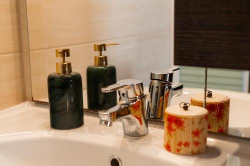 a bathroom sink with two soap dispensers and a mirror at Apartment’s Vasileiou Suite 1 in Preveza