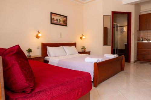 a bedroom with two beds and a red couch at Apartment’s Vasileiou Suite 1 in Preveza