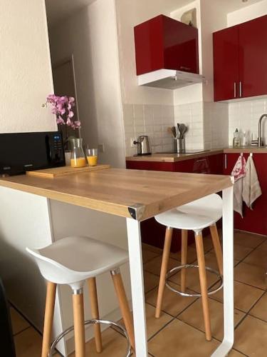 une cuisine avec une table en bois et deux tabourets dans l'établissement T2 JuanOnTheBeach, à Vallauris