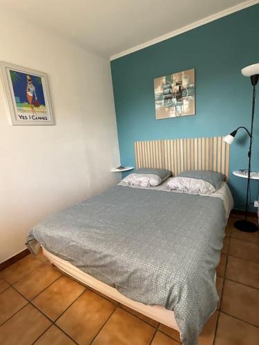 une chambre avec un lit et un mur bleu dans l'établissement T2 JuanOnTheBeach, à Vallauris