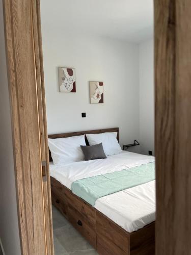 ein Bett mit Holzrahmen in einem Schlafzimmer in der Unterkunft faskomilo house 1 in Faskomiliá