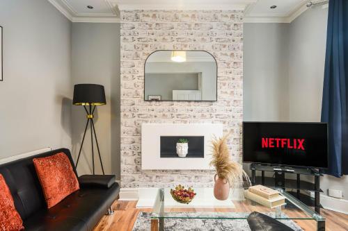 a living room with a couch and a tv at Willow House - 2-Bedroom House In Merseyside! in Birkenhead