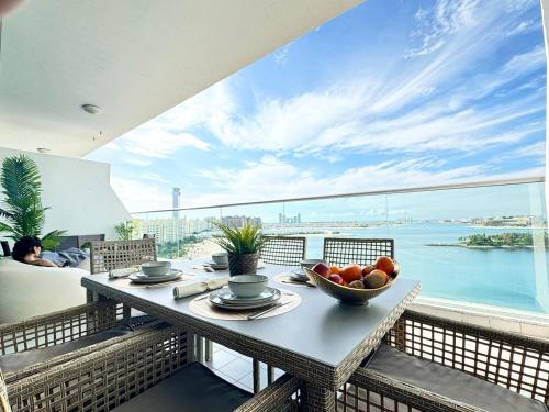 a table with a bowl of fruit on a balcony at GuestReady - Viver com glamour em Palm Jumeirah in Dubai