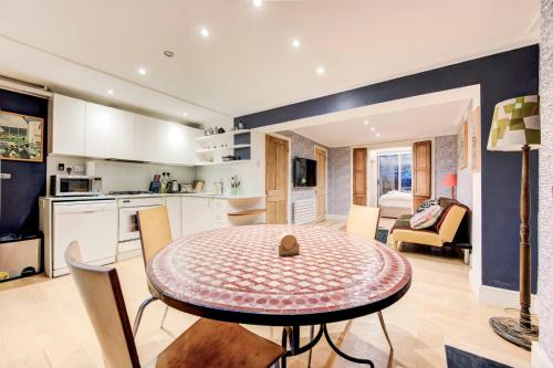 a kitchen and living room with a table and chairs at GuestReady - Lower Ground Classic near The Oval in London