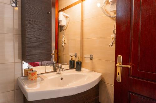 uma casa de banho com um lavatório branco e um espelho. em Apartments Vasileiou Suite 2 em Preveza
