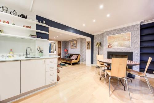 a kitchen and dining room with a table and chairs at GuestReady - Lower Ground Classic near The Oval in London