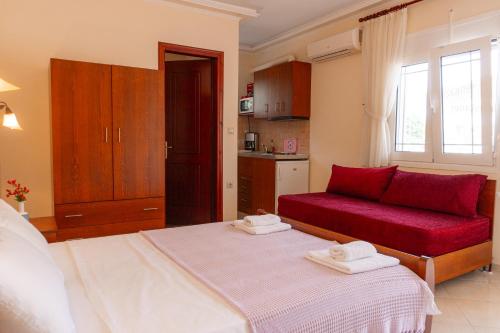 uma sala de estar com uma cama e um sofá vermelho em Apartments Vasileiou Suite 2 em Preveza