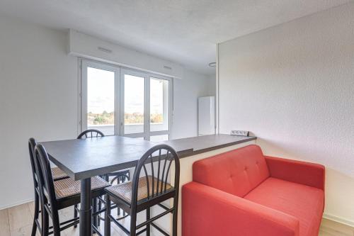 - un salon avec une table et un canapé rouge dans l'établissement GuestReady - Lovely retreat with a balcony, à Mérignac