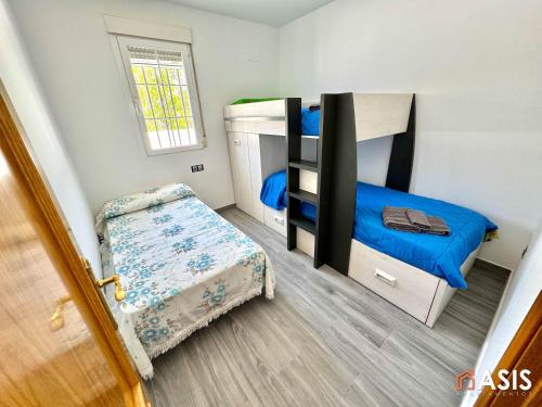 1 dormitorio con 2 literas y 1 cama pequeña en Apartamaento Asis A, en Albuñán