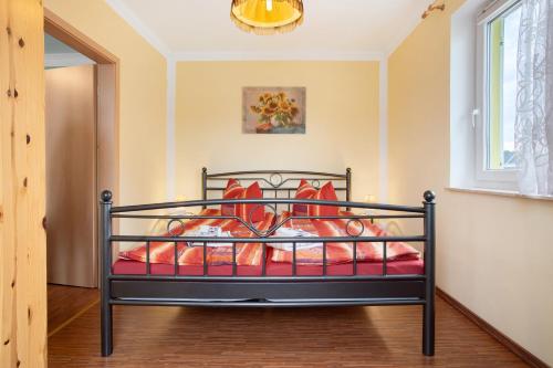 a bedroom with a black bed with orange pillows at Günther - Ferienwohnungen Zinnowitz in Zinnowitz
