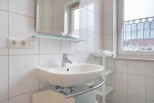 a white bathroom with a sink and a mirror at Günther - Ferienwohnungen Zinnowitz in Zinnowitz