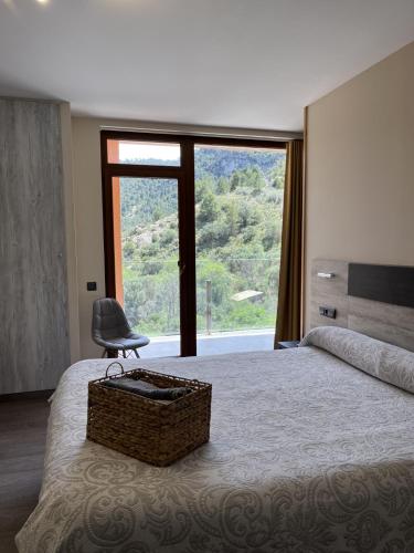 a bedroom with a bed with a chair and a large window at Ca L´Ángels in Prat de Compte