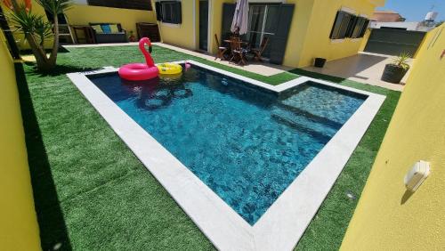 a swimming pool with a pink swan in a yard at Holidays Home Comporta in Comporta