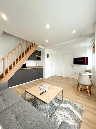 un salon avec un canapé et une table dans l'établissement New duplex 1 minute walking from overground, à Antony