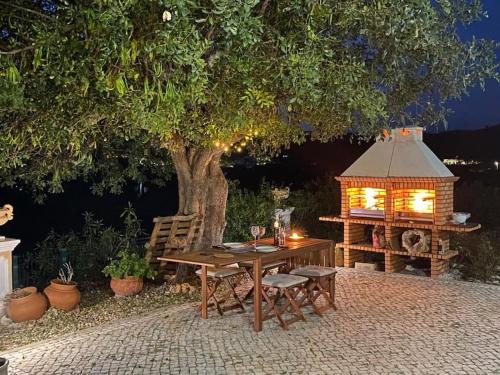 a picnic table and a bird house with a tree at Luxury holiday escape in the countryside tavira in Tavira