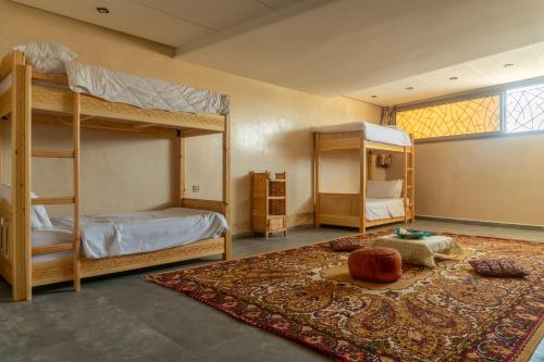 a bedroom with two bunk beds and a rug at Tayyurt host in Agadir