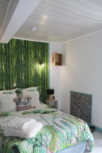 - une chambre avec un lit et du papier peint vert dans l'établissement Le Gîte du Fort, à Saint-Hilaire