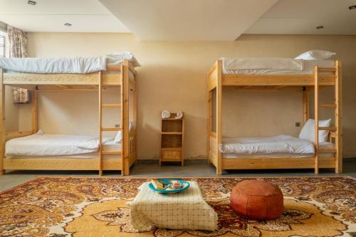 a room with three bunk beds and a rug at Tayyurt host in Agadir