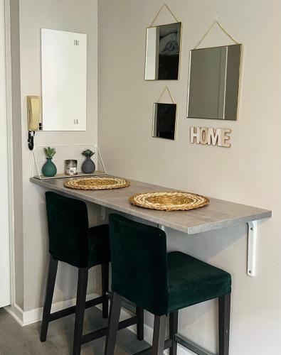 deux pizzas posées sur une table avec des chaises dans l'établissement Charmant & Cosy T2 Toulousain, à Toulouse