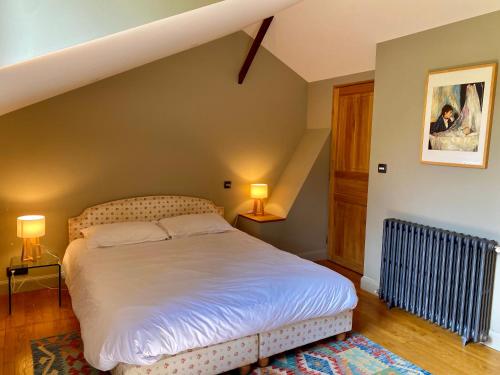 a bedroom with a bed and two lamps and a staircase at Maison avec jardin - L'Orangerie in Thouaré-sur-Loire