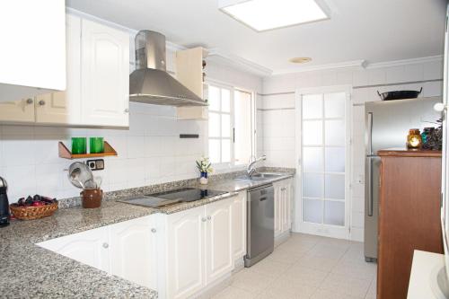 a kitchen with white cabinets and a sink at Vistas Increíbles y Confort en 1ª Línea de Playa in Santa Pola