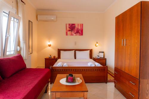 a bedroom with a bed and a red couch at Apartments Vasileiou Suite 4 in Preveza