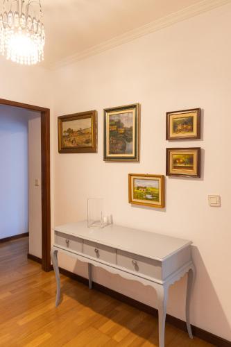 a white table in a room with pictures on the wall at Retreat Hattie's Beach in Arcozelo