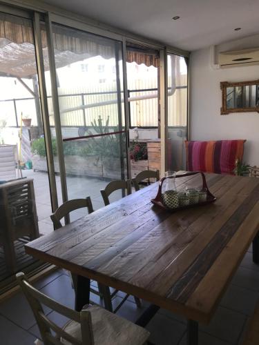 - une table et des chaises en bois dans une chambre avec fenêtre dans l'établissement Grande terrasse proche Cours Julien, à Marseille