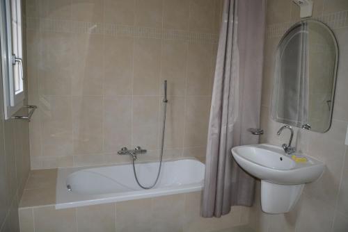 une salle de bain avec un lavabo, une baignoire et des toilettes dans l'établissement Faïza, à La Garonnette-Plage