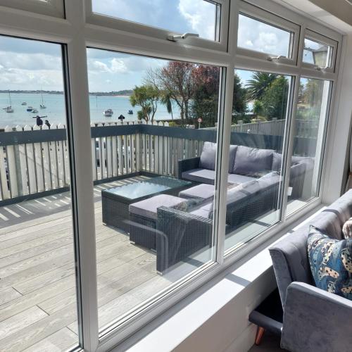 a screened in porch with a view of the water at Gorey retreat main house in Gorey