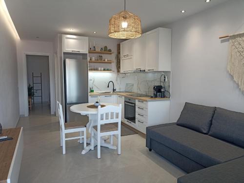 a living room with a couch and a table and a kitchen at Dimitros Apartment II in Neos Marmaras