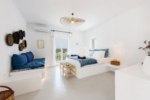 Villa Paralía - Best seaside في Agia Irini Paros: غرفة نوم بيضاء مع سرير وأريكة