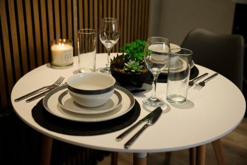 un tavolo bianco con ciotola, piatti e bicchieri da vino di Luxury - Close To Centre - Free Parking - 4 Beds a Manchester