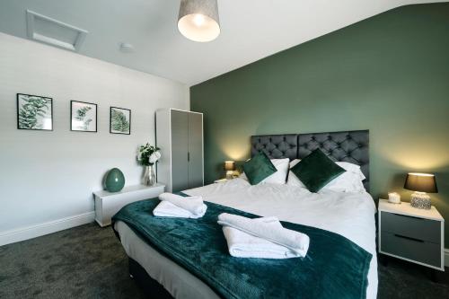 una camera da letto con un grande letto con due asciugamani di Luxury - Close To Centre - Free Parking - 4 Beds a Manchester