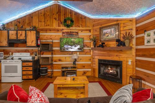 a living room with wooden walls and a fireplace at Cozy Bears Cabin by Eden Crest in Pigeon Forge