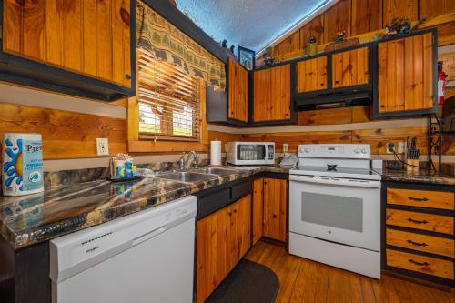 a kitchen with wooden cabinets and white appliances at Cozy Bears Cabin by Eden Crest in Pigeon Forge