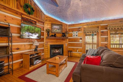 a living room with a couch and a fireplace at Cozy Bears Cabin by Eden Crest in Pigeon Forge