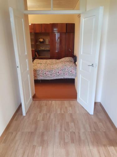 a small bedroom with a bed and a wooden floor at IDEA Guest House / ИДЕА гостевой дом in Alaverdi