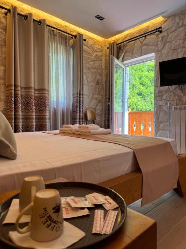 ein Hotelzimmer mit 2 Betten und einem Tisch in der Unterkunft Oda N'Bjeshke in Valbonë