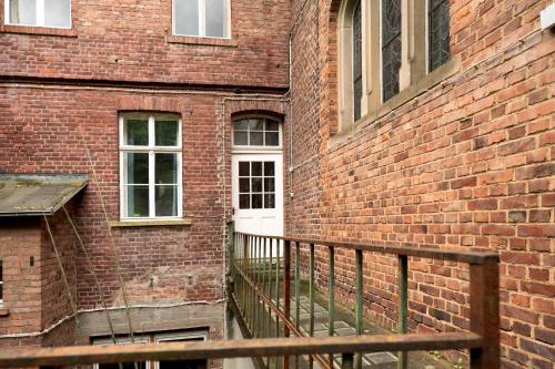 a brick building with a white door and a balcony at Nikola in Merl