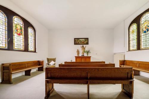a church with wooden pews and stained glass windows at Nikola in Merl