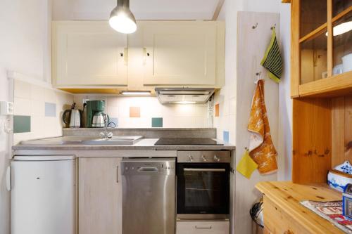 a kitchen with white cabinets and a sink and a dishwasher at Nikola in Merl