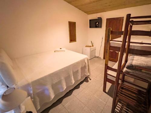 a bedroom with a bed and two bunk beds at Pousada Beira Mar in Caraíva